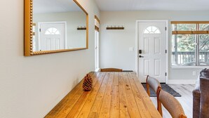 A dining area with a wooden table, chairs, a large mirror, and a door with a window. - 1 Mi to Stagecoach Chairlift: Stateline Condo (Stateline)