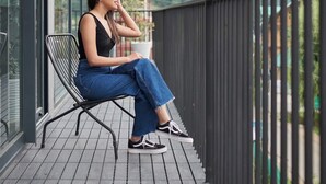 A person sitting on a balcony with a view of mountains.