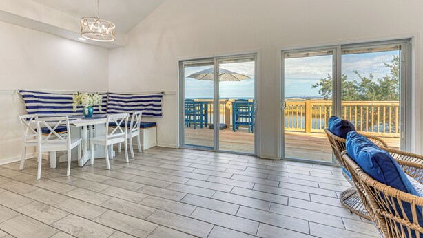 Amplia habitación con comedor, zona de estar con vistas y puerta corrediza que da a una terraza exterior.