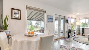 A dining area with a round table, chairs, and a view through glass doors to an outdoor patio. - Fish & Hike: Quiet Smith River Cabin Near Ocean! (Smith River)