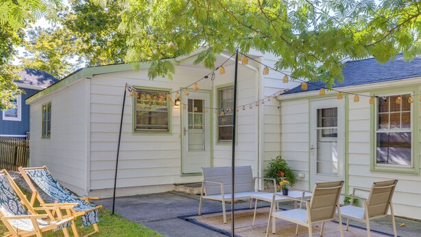 A small house with a patio area featuring outdoor furniture and string lights. - Home w/ Private Yard in Rocky Point (Rocky Point)