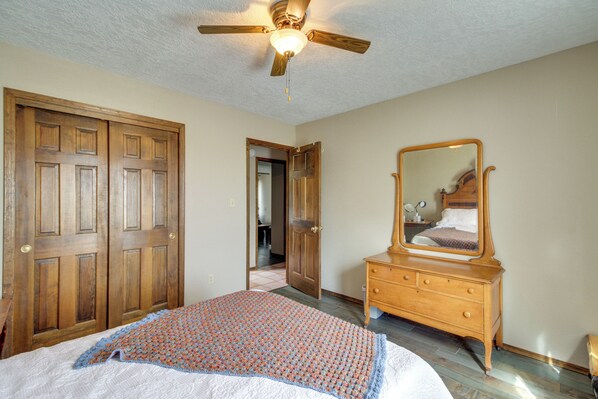 A bedroom with a bed, wooden wardrobe, dresser, and a ceiling fan. - Hiking Nearby! Mountain-view Home Outside ABQ (Edgewood)