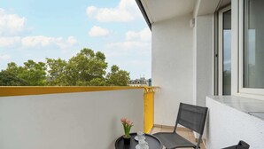 A balcony with a small table, two chairs, and a potted plant. - Spacious Apartment in the Center | Balcony and Air Conditioning (Wrocław)