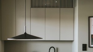 Eine moderne Küche mit schwarzem Arbeitsplatz, einem Wasserkocher und einer Kaffeemaschine.