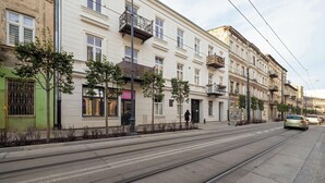 A street with tram tracks, buildings with balconies, and a pedestrian crossing. - Cozy Apartment | Close to Manufaktura and Piotrkowska Street (Łódź)