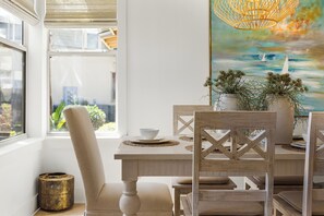 Un comedor con una mesa, sillas y vistas por una ventana.