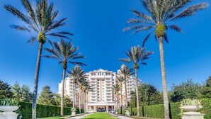 A hotel with a central entrance, surrounded by palm trees and a well-maintained lawn. - Magical Lake View Escape! (Kissimmee)