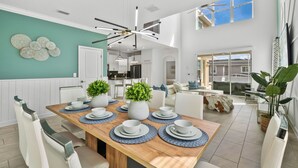 A spacious dining area with a wooden table set for four, surrounded by white chairs.