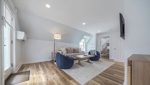 A modern living room with a sofa, two armchairs, a coffee table, and a TV. - Renovated 3BR Home in Downtown SWH [Mariners Rest] (Southwest Harbor)
