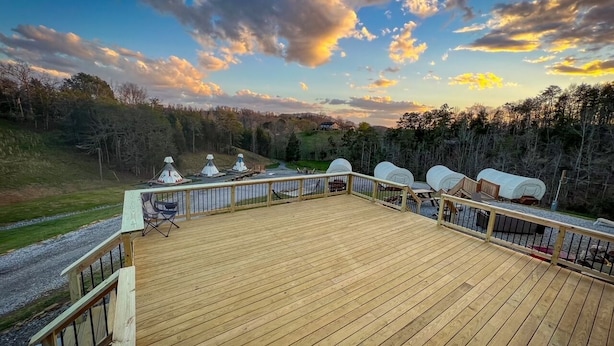 A wooden deck with a railing, a chair, and a small table. - Where the stars are brighter, the nights are quieter, and the Smokies feel alive (Sevierville)