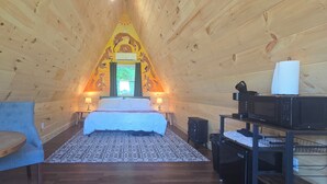 A cozy room with a bed, a chair, a table, and a microwave. - Where the stars are brighter, the nights are quieter, and the Smokies feel alive (Sevierville)