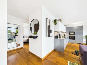 A modern interior with a kitchen, dining area, and living space. - Sleek Camden Town Balcony Apartment (Greater London)