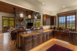 Una cocina amplia con una isla grande, armarios de madera y una pared decorativa de piedra.