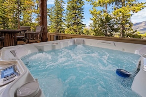 A hot tub with a view of trees and mountains.