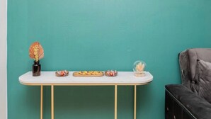 Una pared color turquesa con una mesa blanca mostrando diversos objetos.