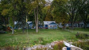 Une propriété située au bord d’un lac, dotée d’un quai pour bateaux, d’une pelouse et d’un petit étang.