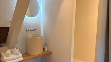 A modern bathroom with a wooden vanity, a large sink, and a bathtub.
