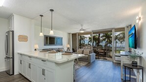A modern kitchen with a large island, white cabinetry, and pendant lighting.