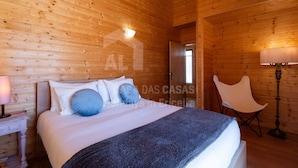 Une chambre à coucher aux murs lambrés, avec un lit, une table de chevet, une lampe et une chaise.