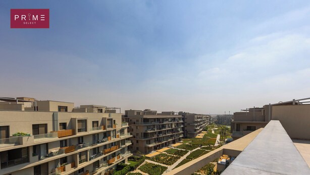 A modern residential building with multiple balconies, a rooftop terrace, and a landscaped garden area.