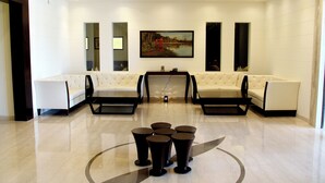 A modern lobby with a seating area, a coffee table, and a painting on the wall.