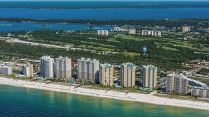 Zona costera con edificios altos, una playa y una extensión de agua.