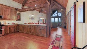 Una cocina amplia con armarios de madera, una isla grande e iluminación colgante.