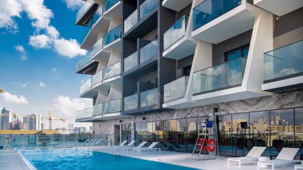 A modern building with a rooftop pool, glass balconies, and a city view. - Elegant 1BR Stay in Binghatti Heights (Dubai)