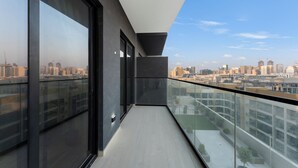 A modern balcony with a city view, large windows, and a glass railing. - Elegant 1BR Stay in Binghatti Heights (Dubai)