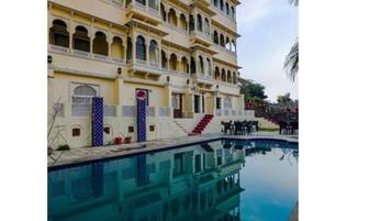 A multi-story building with a pool in front.