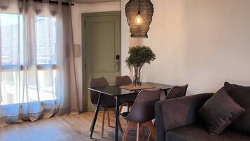 Un espace repas comprenant une table, des chaises et un luminaire suspendu.
