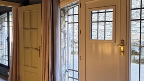 Un conjunto de puertas con un muro de piedra y una ventana.