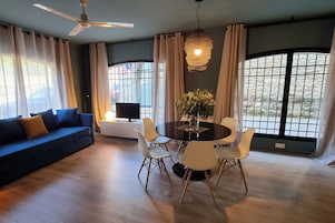Apartamento família, vista para a cidade | Área de estar | TV de tela plana