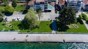 An aerial view of a coastal residential area with buildings, a marina, and a promenade. - Blue Lake Apartments (Ohrid)