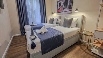 Ein Hotelzimmer mit zwei Betten, einem kleinen Tisch, einer Lampe und einem Bild an der Wand.