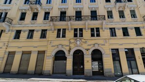A multi-story building with a yellow facade, large windows, and balconies. - Sette Vele Rooms  (Trieste)