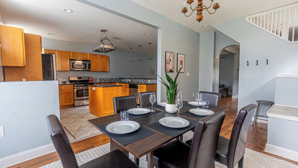 A modern kitchen with wooden cabinets, a stainless steel refrigerator, and a built-in oven. - Spacious Modern 7BR Retreat ~ 3 Story Gem in Pittsburgh (Pittsburgh)