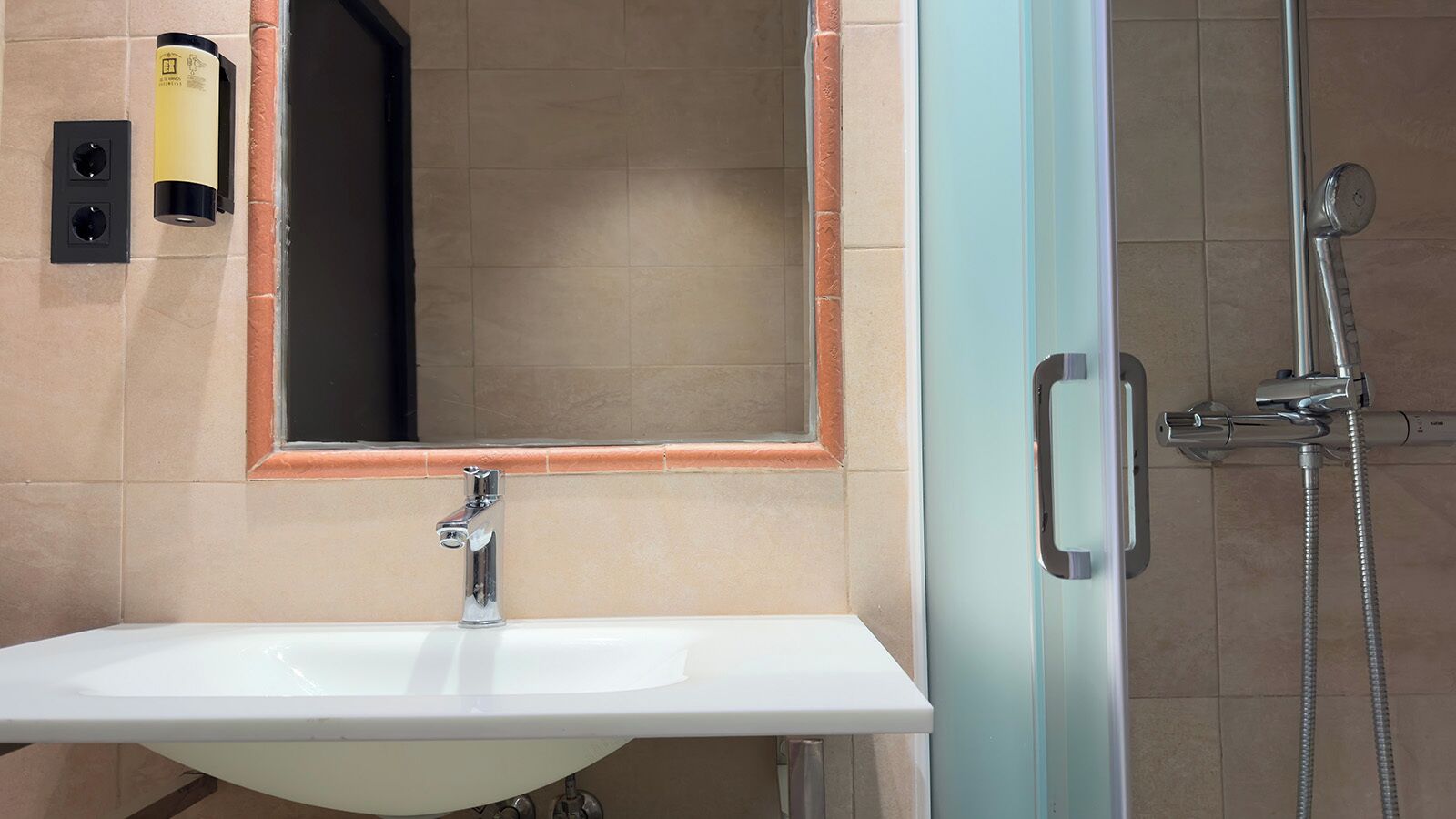 Ein Badezimmer mit Waschbecken, Spiegel und Dusche.