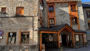 A stone building with wooden balconies and a covered entrance. - La Posada de Ruba (Biescas)