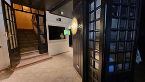 A hotel lobby with a staircase, a reception desk, and a decorative wall piece. - La Posada de Ruba (Biescas)
