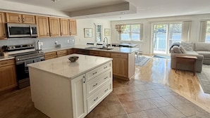 A spacious kitchen with an island, wooden cabinets, and modern appliances. - WATERFRONT ON THOMPSON LAKE (Oxford)