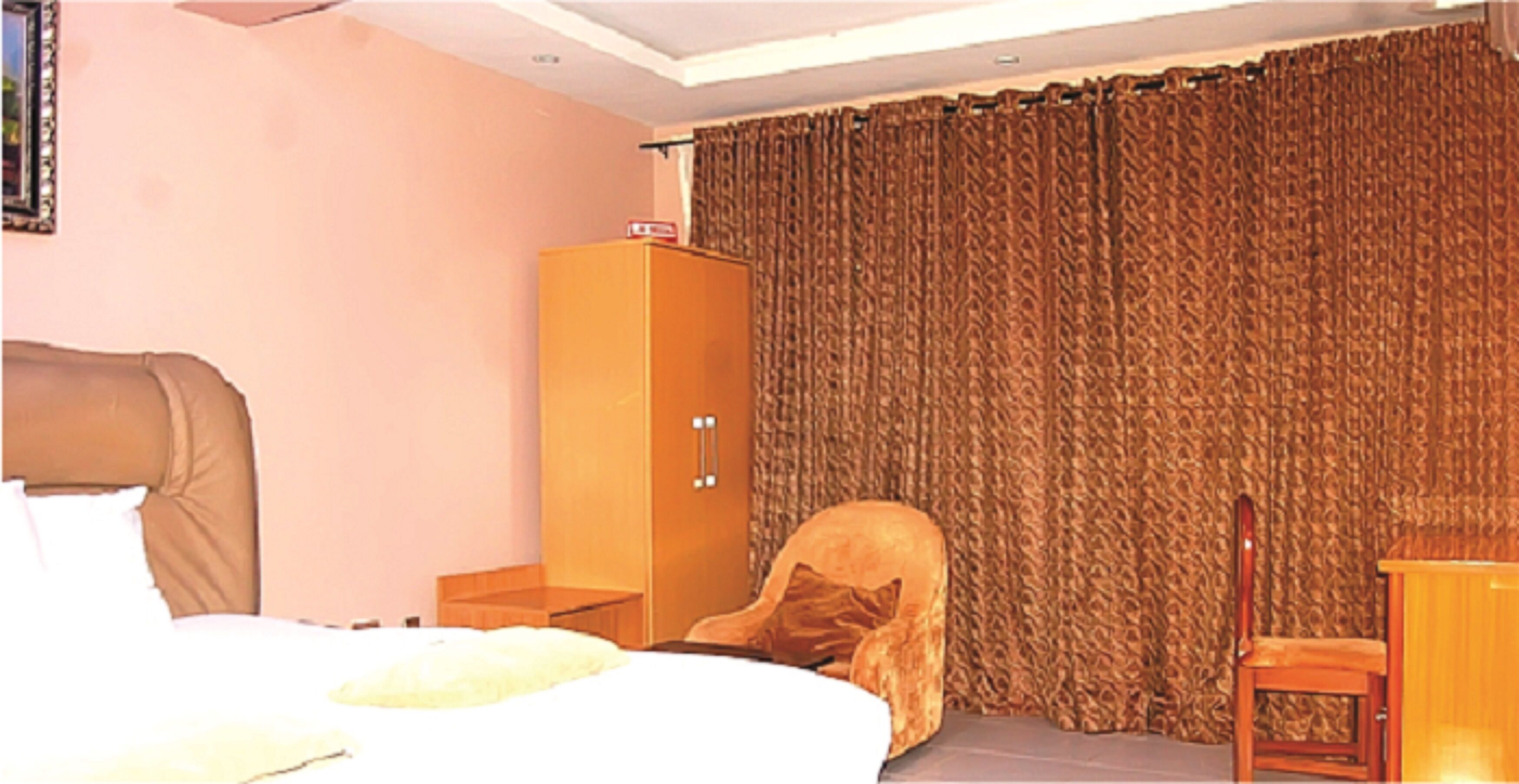 Une chambre d’hôtel avec un lit, une armoire, une chaise et un bureau.