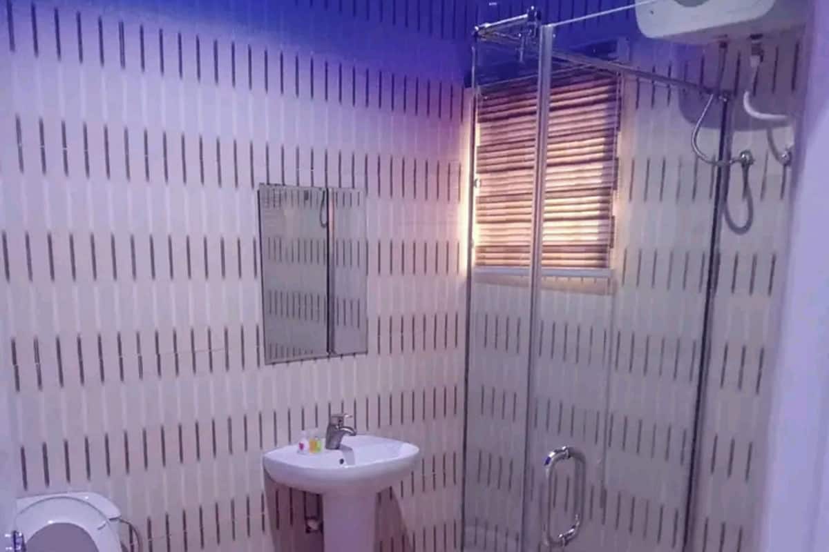 Ein modernes Badezimmer mit Toilette, Waschbecken und Duschkabine aus Glas.