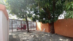 A courtyard with a tree, a red vehicle, and a fence. - Estancia La Quinta María 1. (Veracruz)