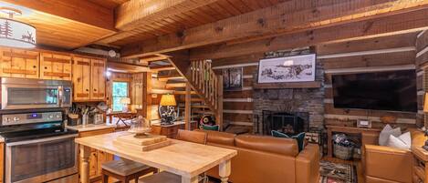 Interior acogedor de una cabaña de madera con cocina, comedor y sala de estar.