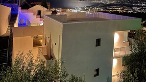 En moderne bygning med tagterrasse med udsigt over bybilledet om natten.