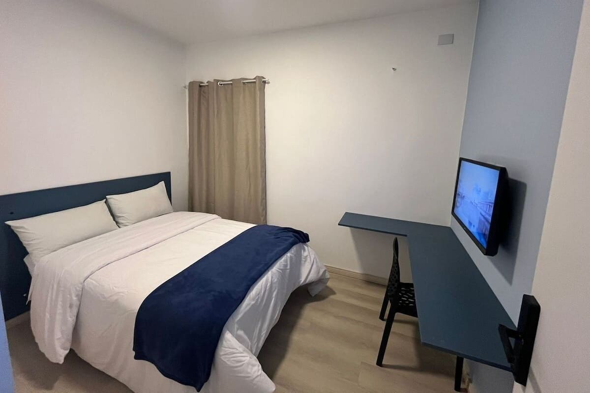 Ein Hotelzimmer mit einem Bett, einem Schreibtisch und einem Fernseher.