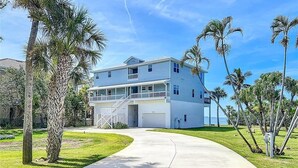A two-story house with a covered front porch, a garage, and a curved driveway.
