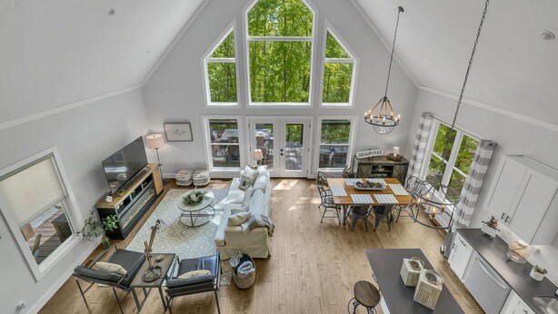 Un loft espacioso con techo alto, ventanas grandes, comedor y cocina.