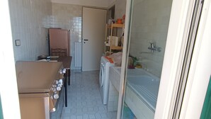 Een kleine badkamer met een bad, toilet en wastafel.